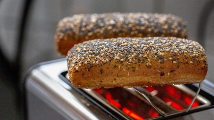 © stock.adobe.com/Waldemar Zwei Körnerbrötchen liegen auf einem Toaster.