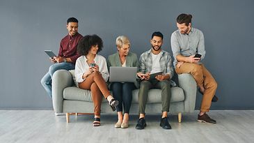 © istockphoto.com/Charday Penn Fünf Leute sitzen auf einer Couch.