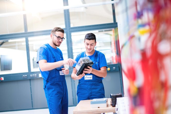 © Mainova/AndreFormer Zwei Auszubildende im Blaumann mit einem Elektromodul