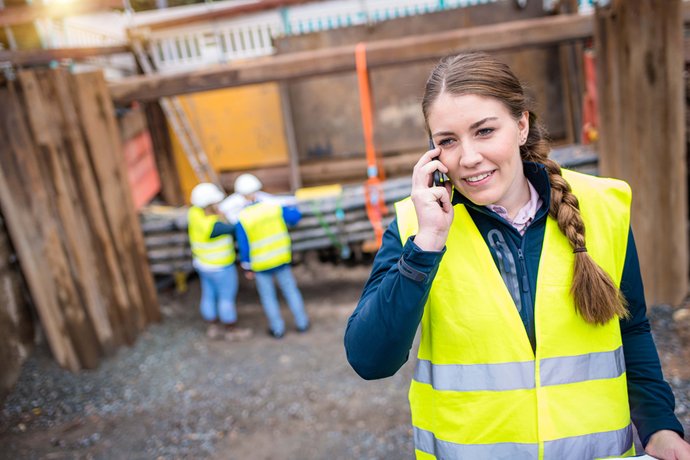 © Mainova/AndreForner Auszubildende telefoniert in einem Graben auf der Baustelle