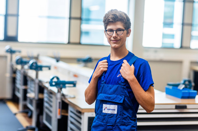 © Mainova/AndreFormer Sebastian Neudeck steht vor einer Werkbank und schaut in die Kamera