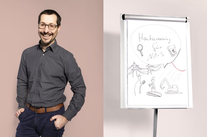 © Ramon Haindl Mann mit Brille und Lächeln, dunkles Hemd; neben Flipchart mit Zeichnung und Text.