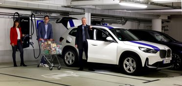 © Mainova AG Drei Menschen in einer Tiefgarage vor einer Schnellladesäule