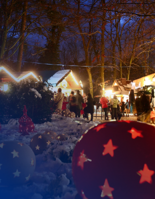 Menschen auf einem Weihnachtsmarkt, beleuchtete Stände