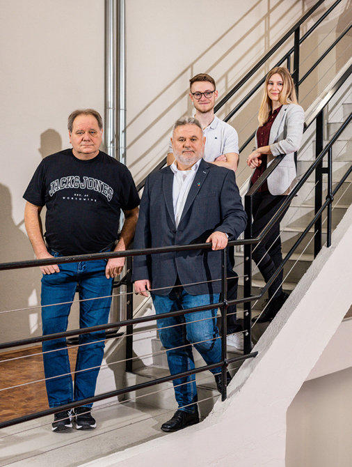© Stilmanöver/RamonHaindl Vier Personen stehen auf einer Treppe und blicken in die Kamera, teils leger, teils geschäftlich gekleidet.