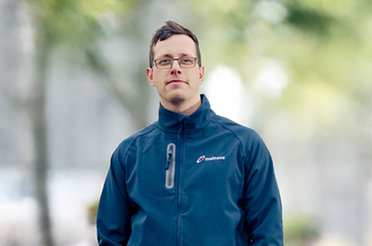 Eine Person in einer blauen Jacke steht draußen.