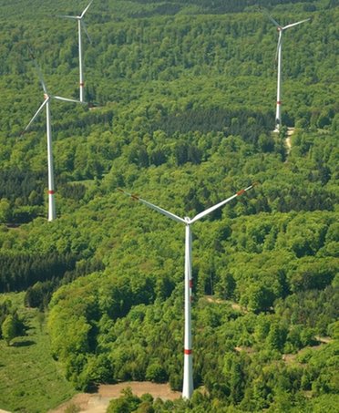© Mainova Vier Windkraftanlagen von Mainova inmitten einer grünen Landschaft aus der Vogelperspektive.