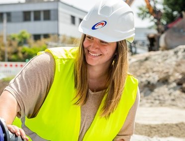 © Mainova Eine Mainova-Mitarbeiterin mit Bauhelm arbeitet an einer Baustelle