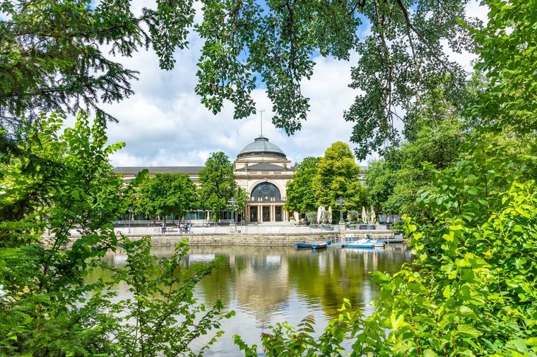 Die Spielbank in Wiesbaden, umgeben von frühlingsgrünen Bäumen