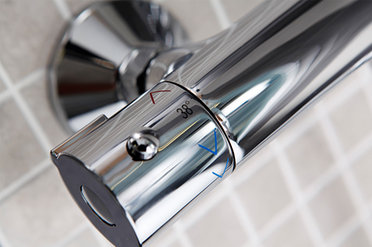 Einhebelmischer mit Thermostat, Aufschrift 38° sowie rote und blaue Pfeile als Warm-Kalt-Kennzeichnung