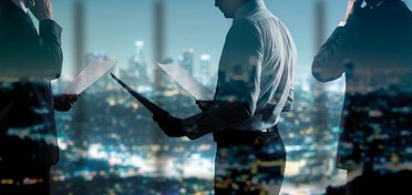 Männer in Businesskleidung vor Skyline