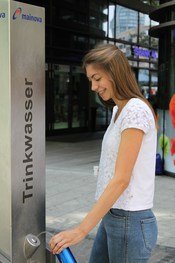 Junge Frau an Trinkwasserstation