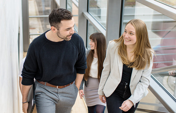 © Mainova/AndreFormer Gruppe mit Studierenden läuft eine Treppe hoch und spricht miteinander