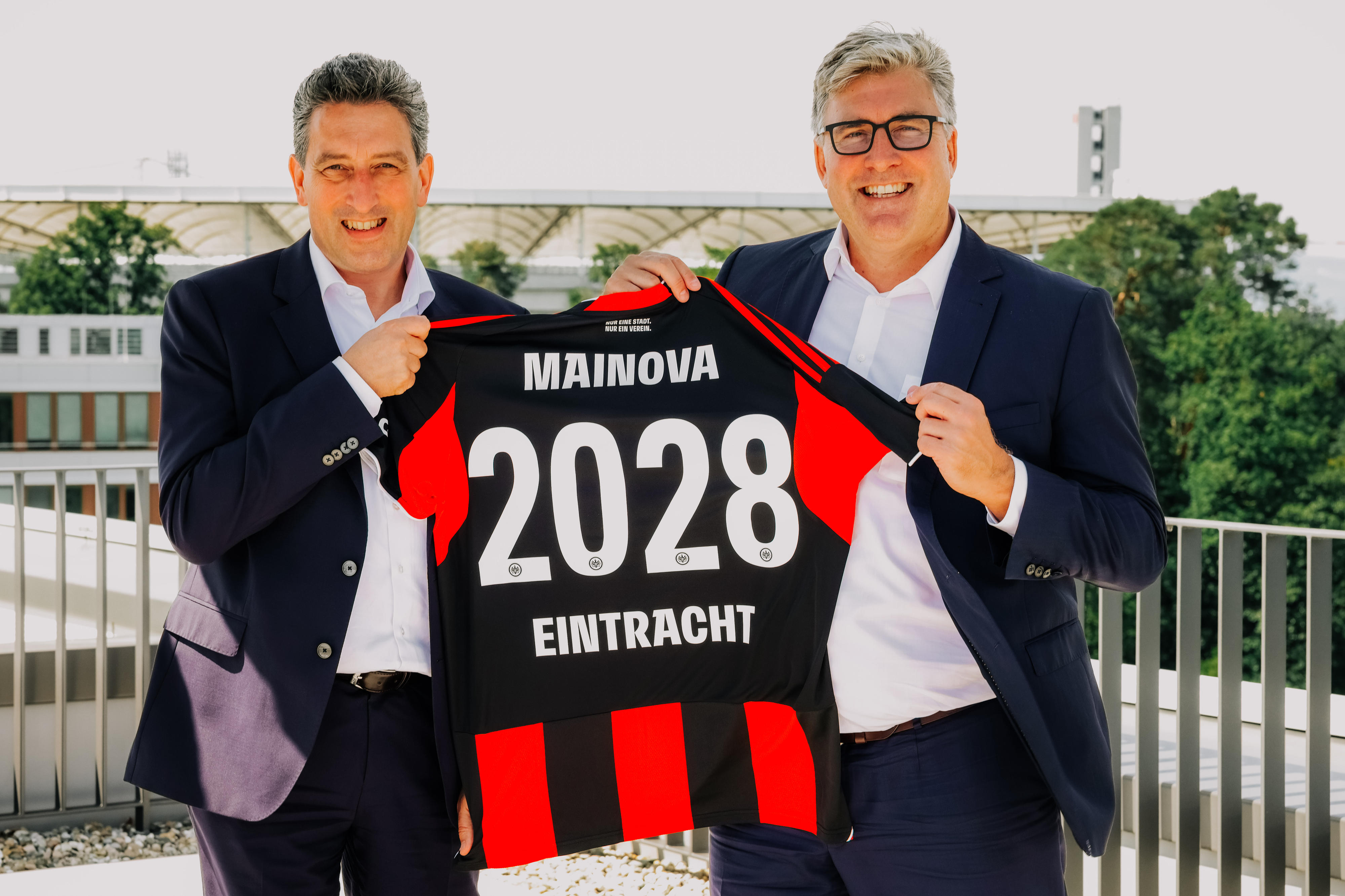 Zwei Männer halten gemeinsam ein Trikot in die Kamera 