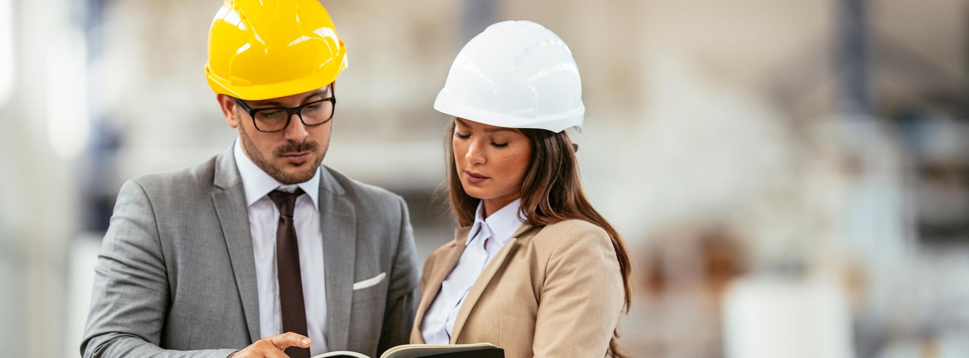 © iStock.com/Boris Jovanovic Geschäftsmann und Geschäftsfrau in Produktionshalle.