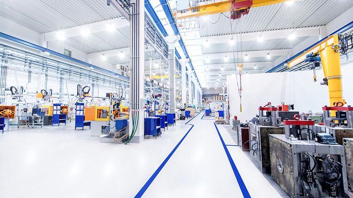 © iStock.com/yoh4nn Hell beleuchtete Produktionshalle mit modernen Maschinen