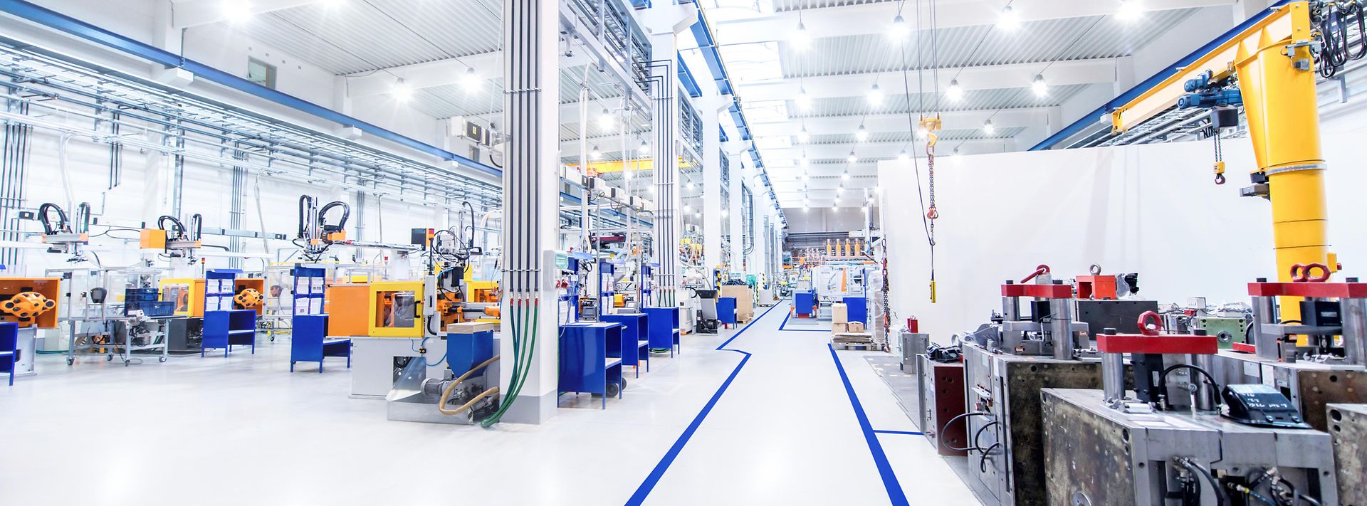 © iStock.com/yoh4nn Hell beleuchtete Produktionshalle mit modernen Maschinen