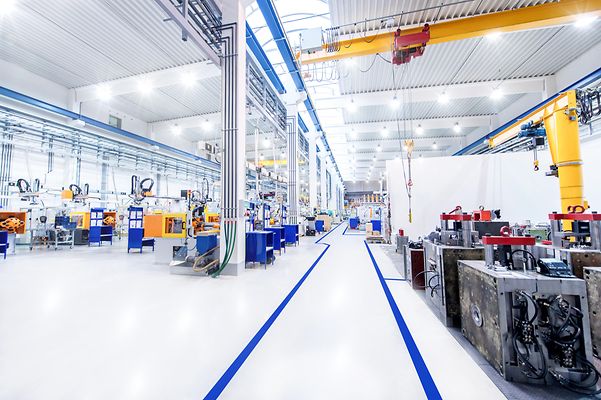 © iStock.com/yoh4nn Hell beleuchtete Produktionshalle mit modernen Maschinen