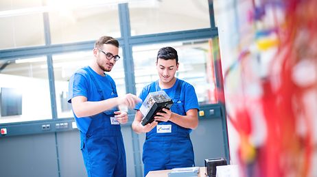 © Mainova/AndreFormer Zwei Auszubildende im Blaumann mit einem Elektromodul