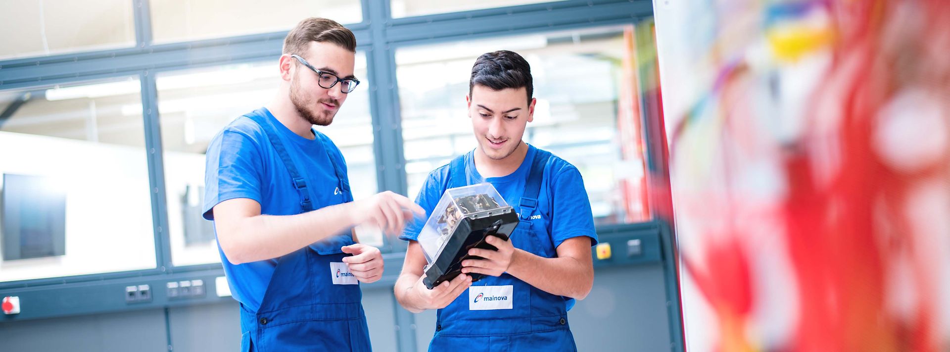 Zwei Auszubildende im Blaumann mit einem Elektromodul