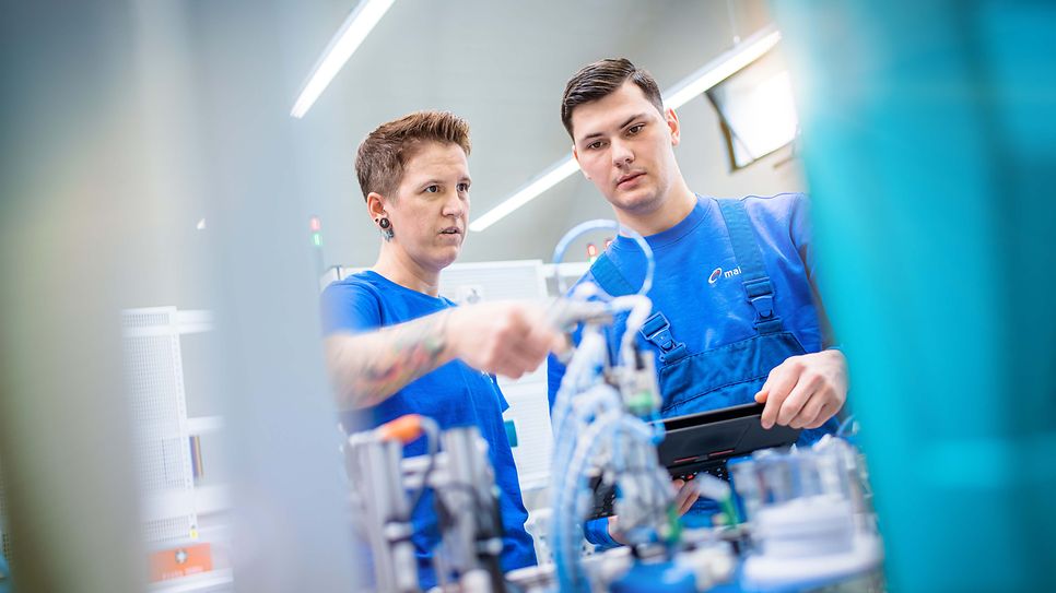 © Mainova/AndreFormer Ausbilder zeigt einem Auszubildenden eine Pneumatikinstallation