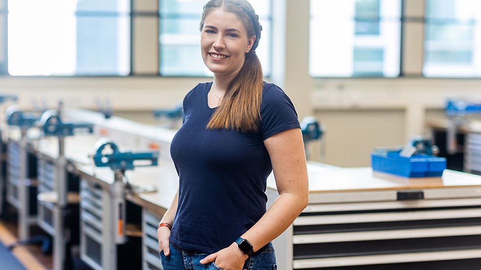 © Mainova/DennisMöbus Charlotte Graf steht angelehnt an einer Werkbank und schaut in die Kamera