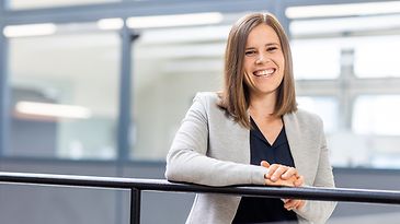 Recruiterin Corinna Kreuzer steht an einem Geländer