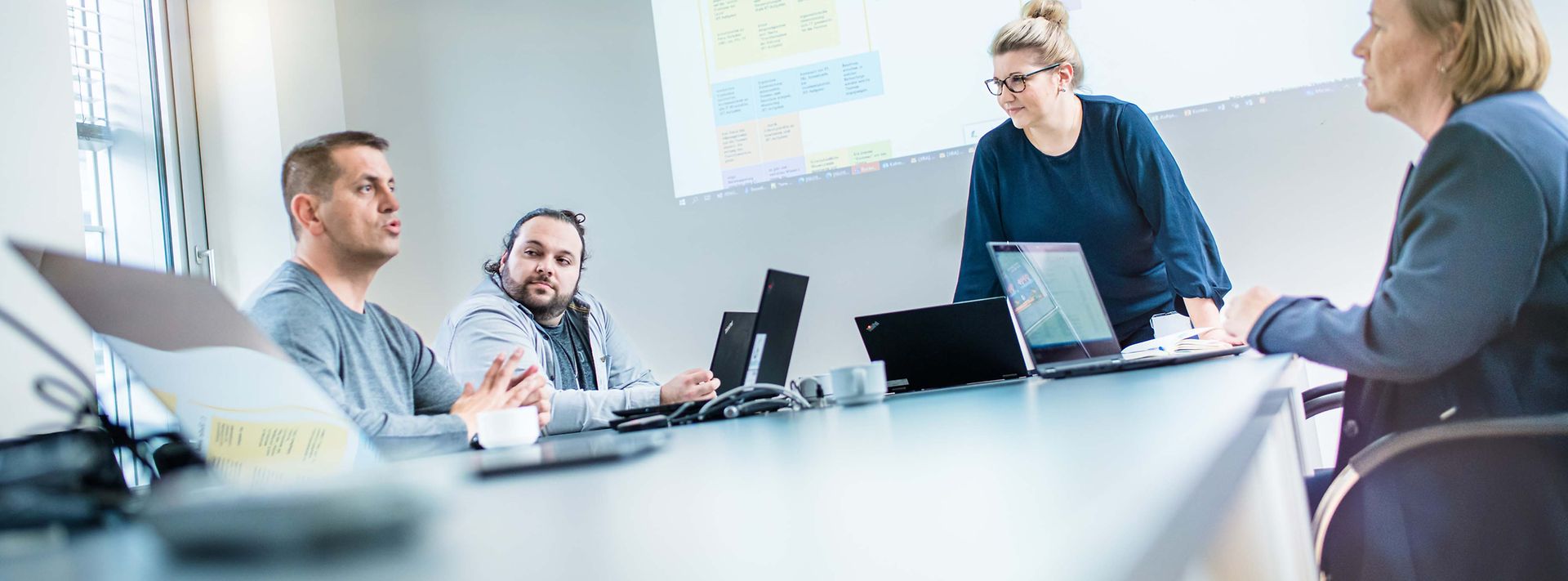 © Mainova/AndreFormer Gruppe sitzt am Konferenztisch und es wird über eine Beamerfolie gesprochen
