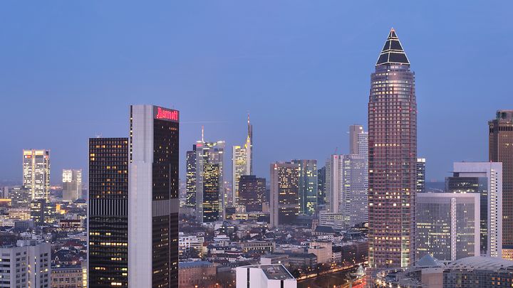 Skyline von Frankfurt bei Dämmerung mit mehreren Hochhäusern, darunter ein Marriott-Hotel.