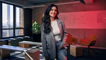 Eine Frau steht mittig in einer Bürofläche 
