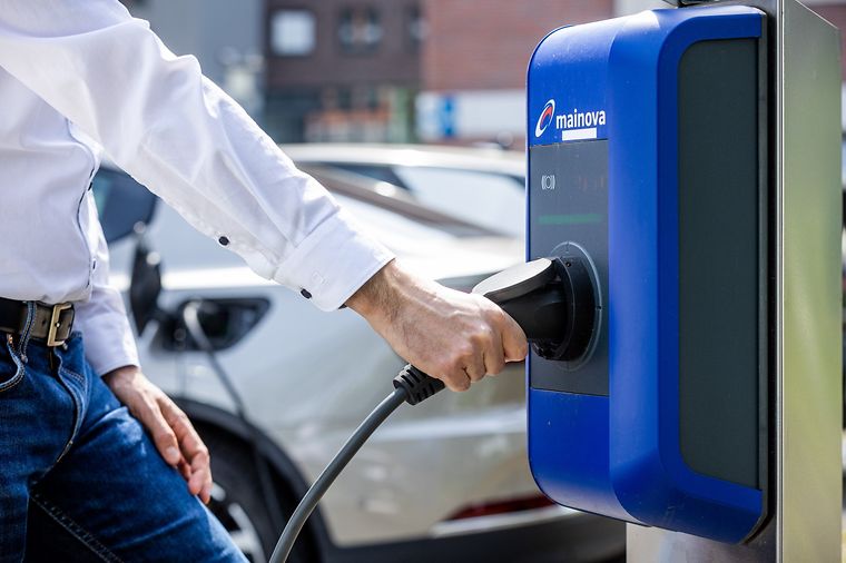 Mann nutzt eine Ladestation von Mainova.