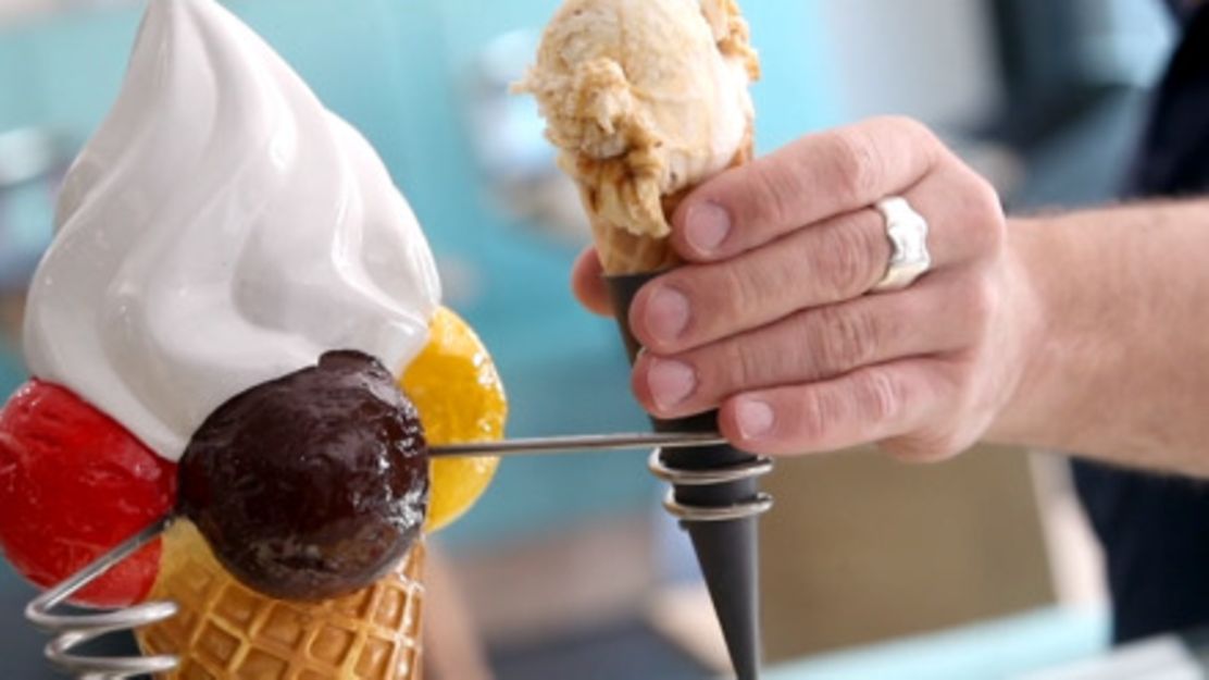 Eiswaffel aus Kunststoff und daneben Hand mit echter Eiswaffel
