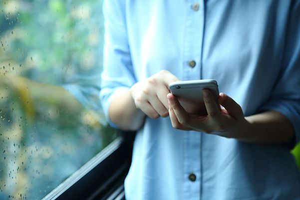 auf dem Handy tippende Person