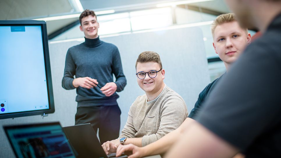 © Mainova/AndreFormer Junge Auszubildende sitzen zusammen und hören einen Auszubildenden zu