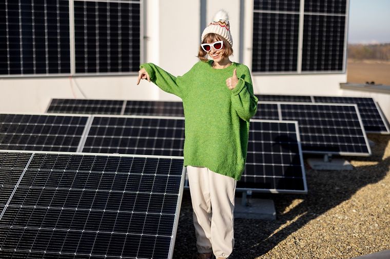 Glückliche Hausbesitzerin mit Solaranlage