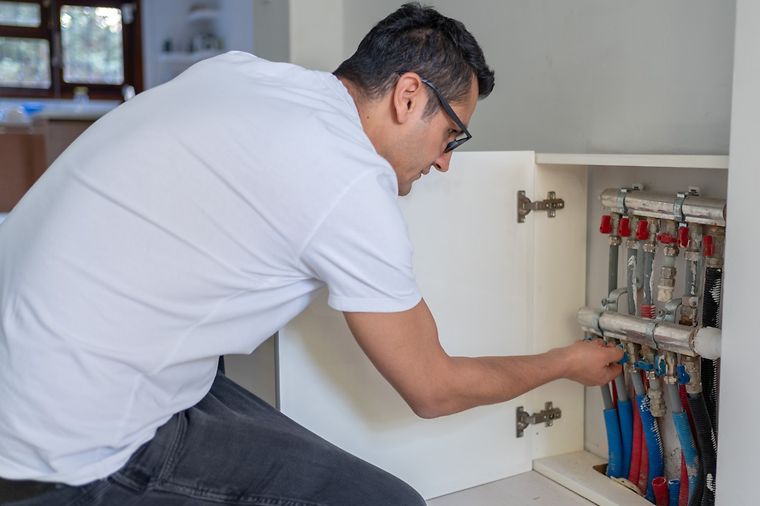 © www.istock.com/aquaArts_studio Mann stellt Hausheizung zu Hause ein