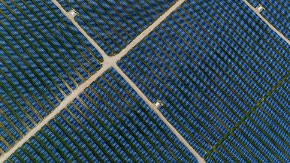 Drohnenansicht von Solarmodulen in geometrischer Anordnung.