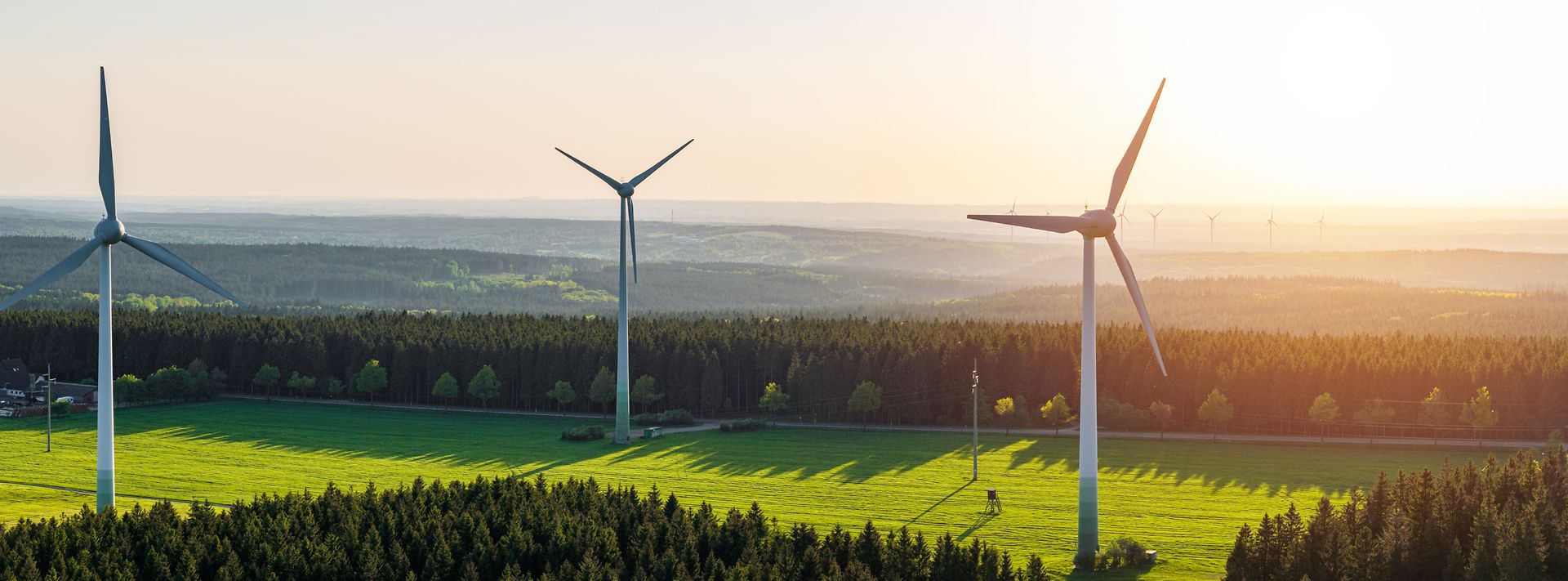 © shutterstock/engel.ac Luftaufnahme von Windrädern und der untergehenden Sonne.