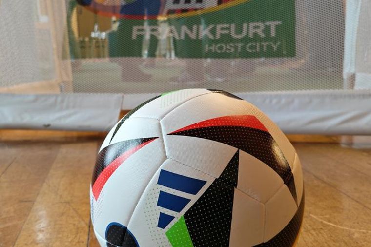 © Lukas Fortkord/dpa Fussball mit dem Motiv für die EM 2024. Im Hintergrund der Schriftzug: Frankfurt.Host City.