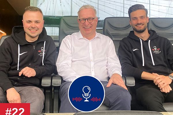 Drei Männer sitzen im Stadion. Von links nach rechts: Podcastmoderator Basti, Stadionchef Patrick Meyer, Podcastmoderator Marco