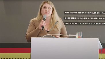 © Mainova Frau Wüst spricht an einem Rednerpult in ein Mikrofon.