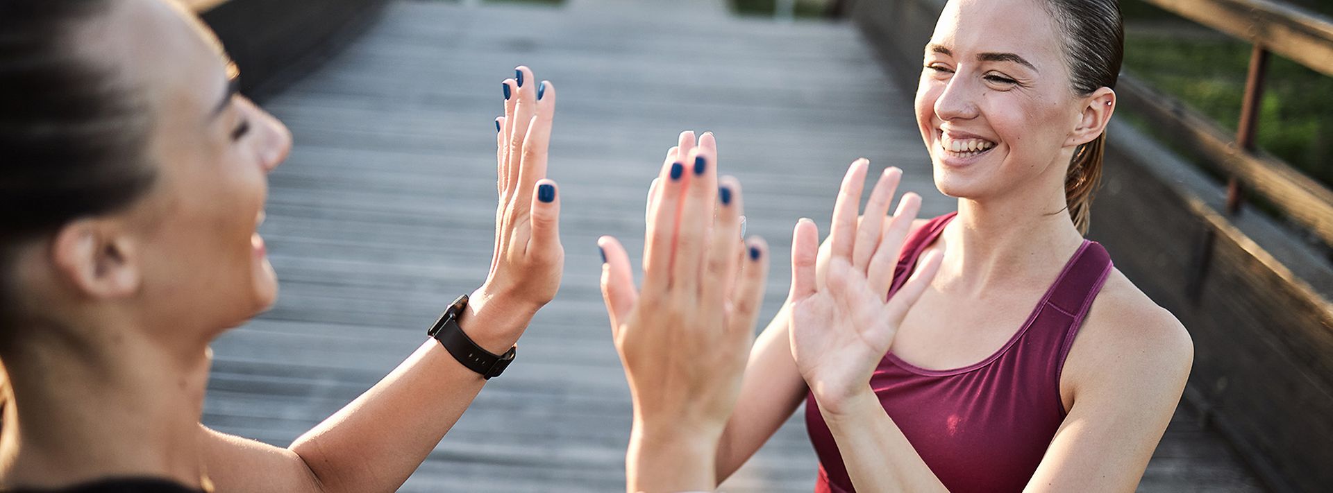 Zwei Sportlerinnen klatschen sich lächelnd ab