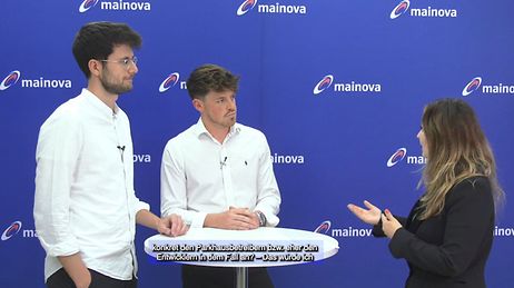© Mainova AG 2 Männer stehen links von einer Frau und reden mit ihr vor einer Mainova Wand