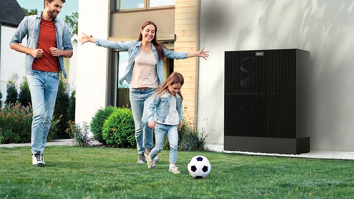 © Viessmann Eltern und Tochter spielen Fußball im Garten, das Mädchen rennt mit Ball vorneweg