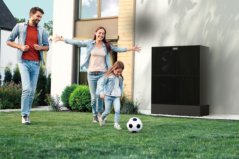 © Viessmann Eltern und Tochter spielen Fußball im Garten, das Mädchen rennt mit Ball vorneweg