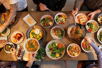 Asiatisches Essen auf Tellern auf einem Tisch von oben