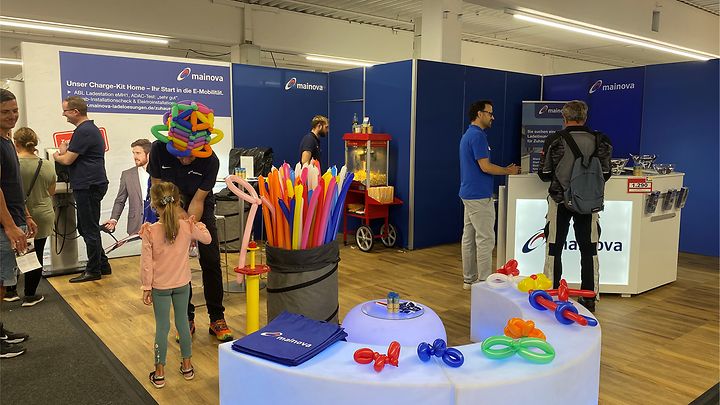 Mainova Stand der Baumesse mit Erwachsenen und Kindern davor