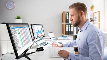 © www.istock.com - AndreyPopov Mann sitz am Schreibtisch mit Monitor auf dem eine E-Rechnung sichtbar ist