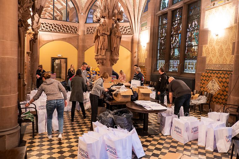 © Jan Ole von joh media Ratskeller des Frankfurter Römers, viele Personen packen Geschenktüten ein