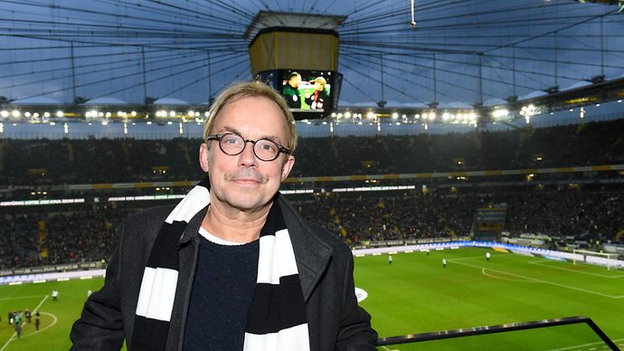 Mann steht mit Eintrachtschal im Stadion der Eintracht